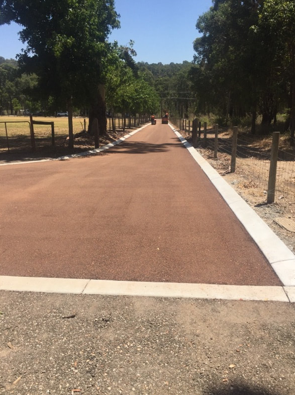 This is a photo of a hot spray & seal bitumen roadway which is in the process of being installed by Langwarrin Surfacing Solutions